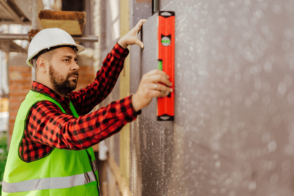 Ein Handwerker Legt Eine Wasserwaage An Einer Hauswand An